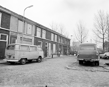 858751 Gezicht op de gedeeltelijk dichtgetimmerde en voor sloop bestemde huizen Kolfstraat 35 (links) -27 te Utrecht.